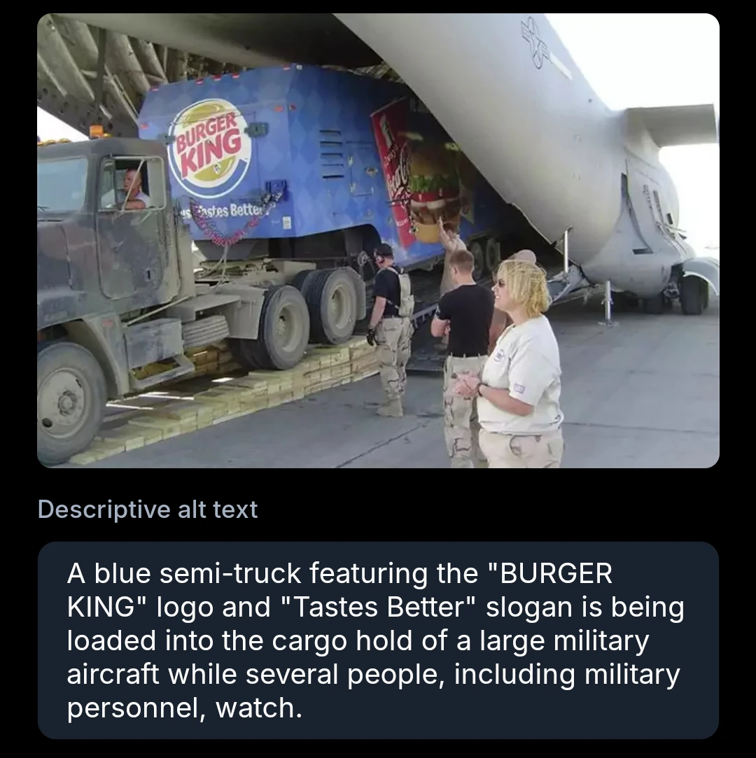 A blue semi-truck featuring the "BURGER KING" logo and the "Tastes Better" slogan is being loaded into the cargo hold of a large military aircraft while several people, including military personnel, watch.